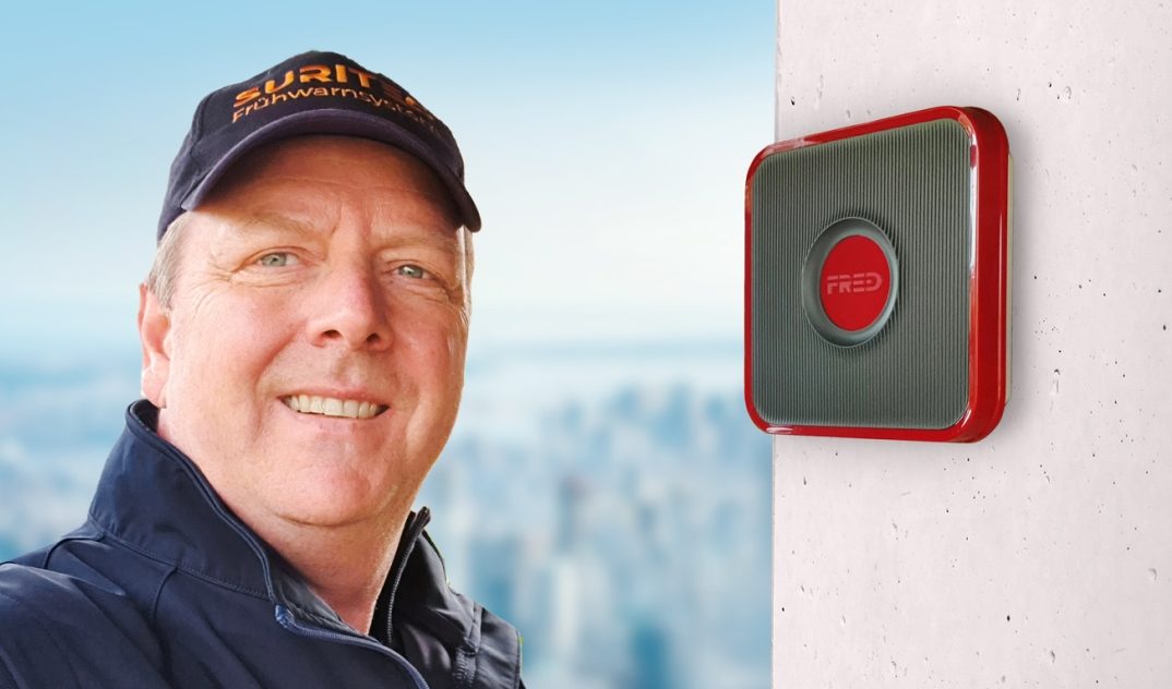 Michael Meyer von MM Alarmanlagen neben dem Suritec Frühwarnsystem FRED an der Hauswand